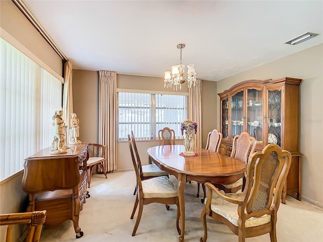 carpeted dining room featuring an inviting chandelier