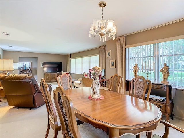 carpeted dining area featuring a notable chandelier