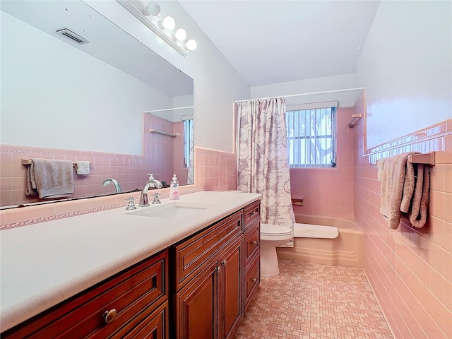 full bathroom featuring shower / bath combination with curtain, toilet, tile walls, and vanity