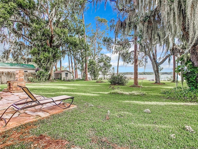 view of yard with a water view and a patio