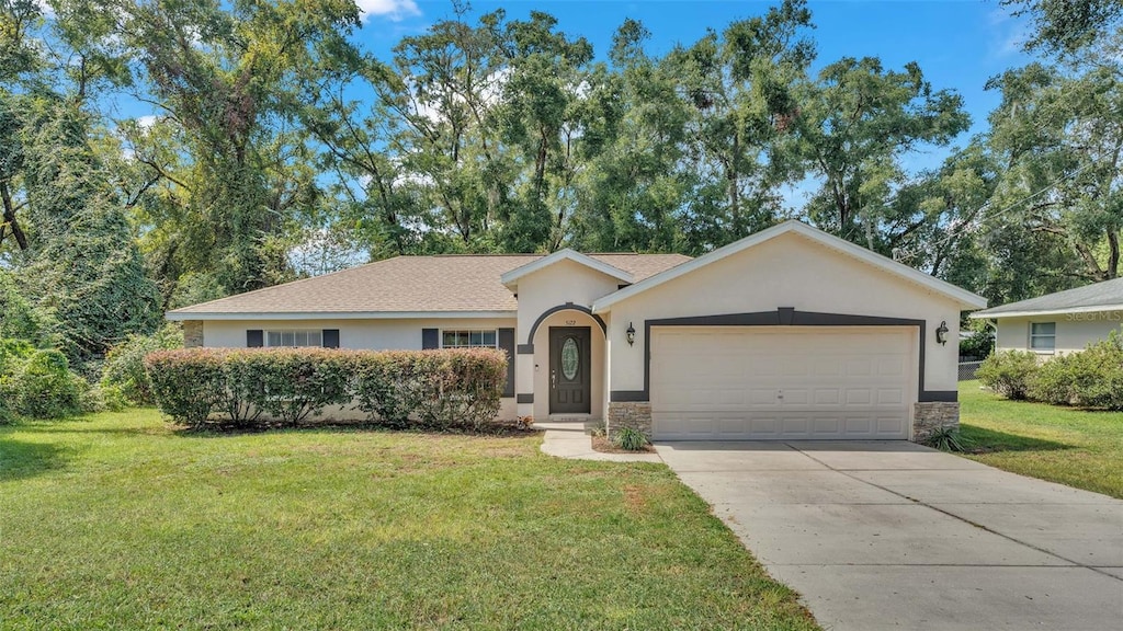 ranch-style home with a garage and a front lawn