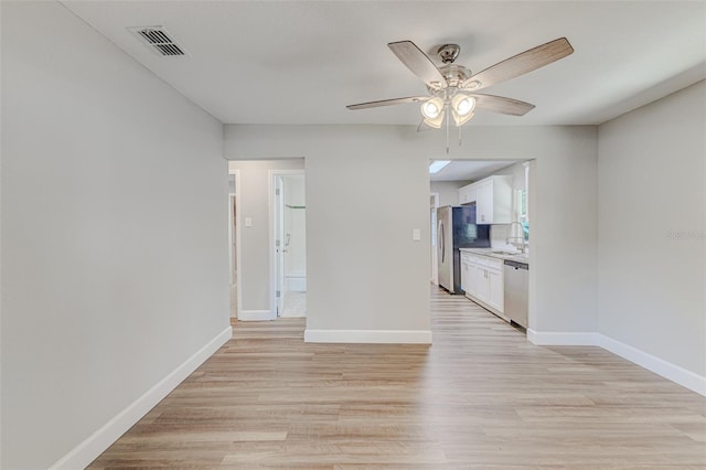 unfurnished room featuring light hardwood / wood-style floors, sink, and ceiling fan