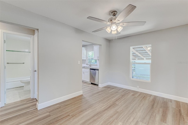 spare room with light hardwood / wood-style flooring, ceiling fan, and sink