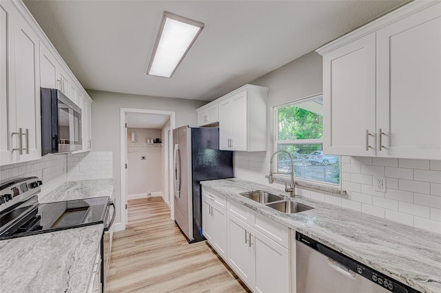 kitchen featuring decorative backsplash, stainless steel appliances, light hardwood / wood-style floors, and sink