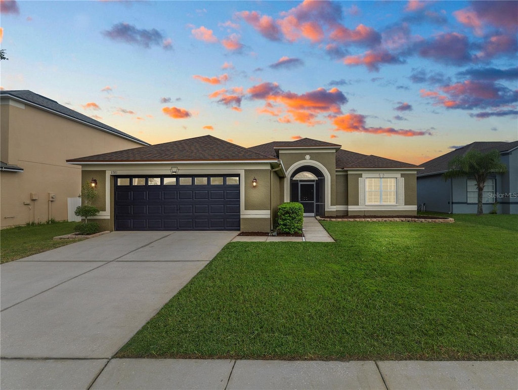 view of front facade with a yard and a garage