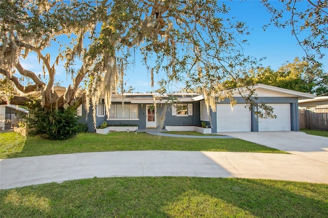 ranch-style home featuring stucco siding, an attached garage, a front yard, fence, and driveway