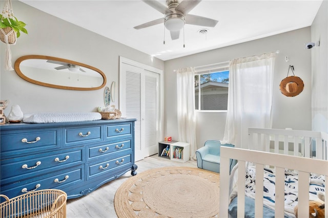 bedroom featuring ceiling fan, a closet, and light hardwood / wood-style floors