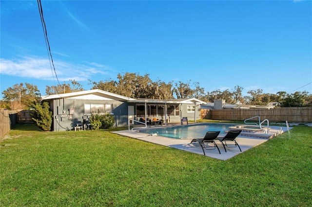 back of property featuring a yard, a fenced in pool, and a patio area