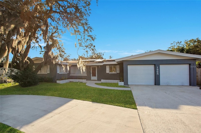 ranch-style home with a garage, driveway, a front lawn, and stucco siding