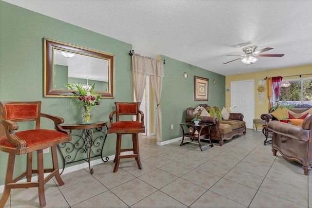 tiled living room with ceiling fan and a textured ceiling