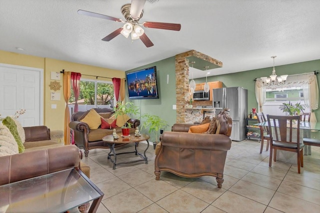 living room featuring ceiling fan with notable chandelier, a textured ceiling, and light tile patterned flooring