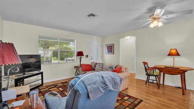 living room with ceiling fan, hardwood / wood-style floors, and a textured ceiling