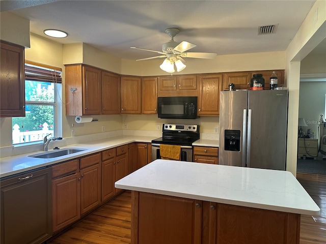 kitchen with stainless steel appliances, dark hardwood / wood-style floors, a center island, and sink