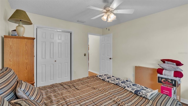 bedroom with a textured ceiling, ceiling fan, and a closet