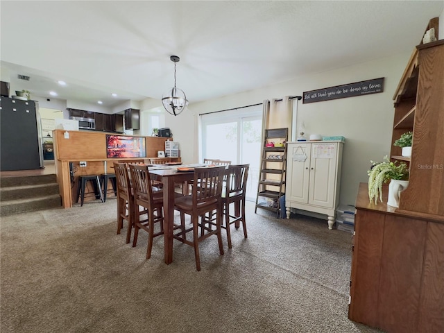 carpeted dining area featuring an inviting chandelier