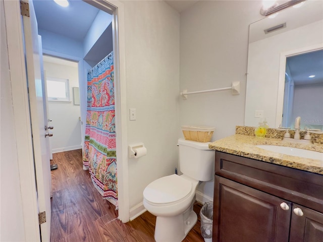 bathroom with vanity, hardwood / wood-style floors, toilet, and curtained shower