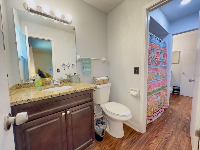 bathroom featuring walk in shower, hardwood / wood-style flooring, vanity, and toilet