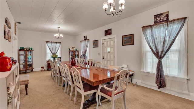 carpeted dining space featuring an inviting chandelier