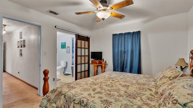 carpeted bedroom with ceiling fan and ensuite bathroom