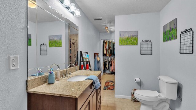 bathroom with vanity, curtained shower, a textured ceiling, tile patterned floors, and toilet