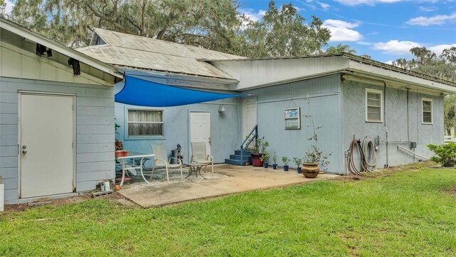 rear view of house featuring a yard and a patio area