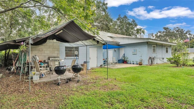 back of property with a patio and a yard