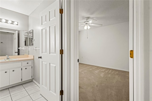 bathroom featuring vanity, a textured ceiling, ceiling fan, and tile patterned flooring