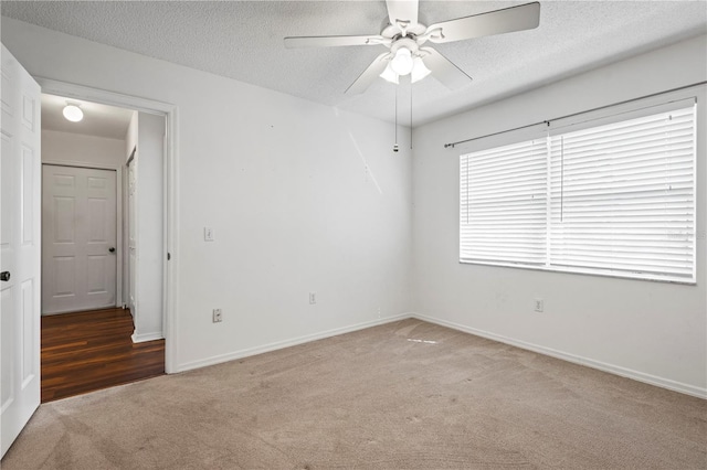 carpeted empty room with a textured ceiling and ceiling fan