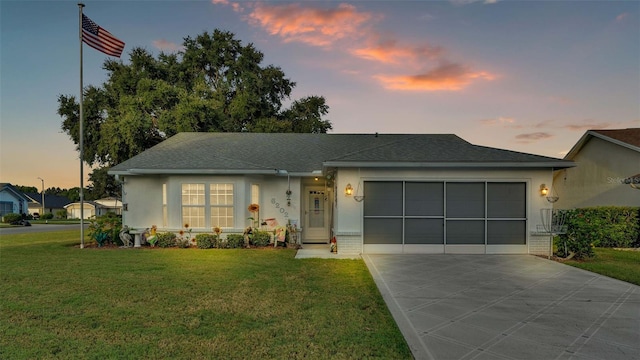 view of front of home featuring a garage and a yard