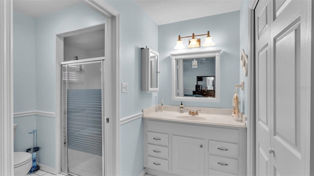 bathroom with tile patterned flooring, vanity, toilet, and a shower with shower door