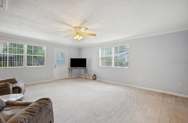 carpeted living room with a textured ceiling, ceiling fan, and crown molding