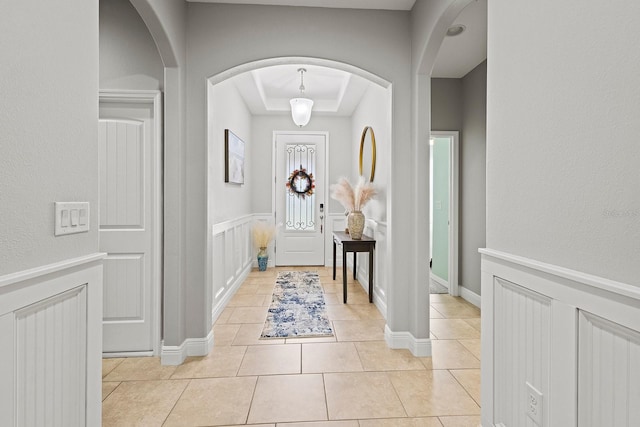 tiled foyer with a tray ceiling