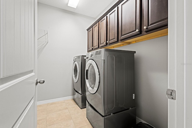 clothes washing area featuring cabinets, light tile patterned flooring, and separate washer and dryer