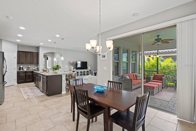 tiled dining area with sink and ceiling fan with notable chandelier