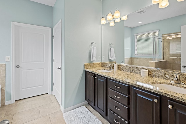 bathroom featuring tile patterned flooring, vanity, and a tile shower