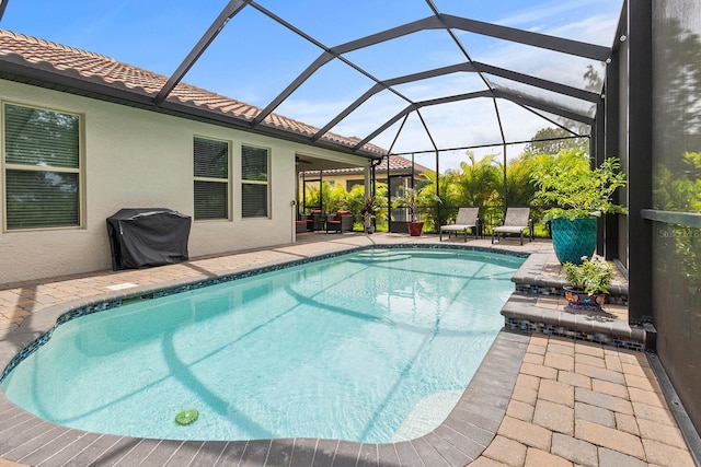 view of pool featuring a grill, a patio area, and glass enclosure