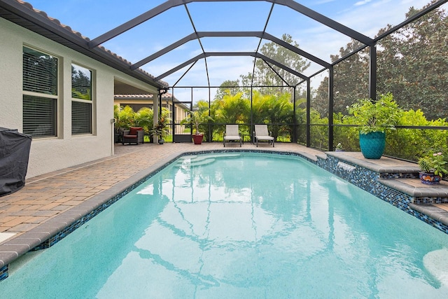 view of swimming pool with pool water feature, a lanai, and a patio