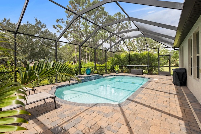 view of pool with a patio and glass enclosure