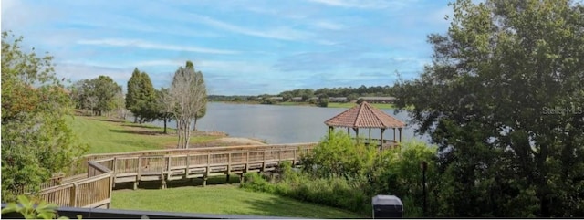 view of dock featuring a water view, a yard, and a gazebo