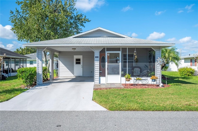 view of front of property featuring a carport, a sunroom, and a front yard