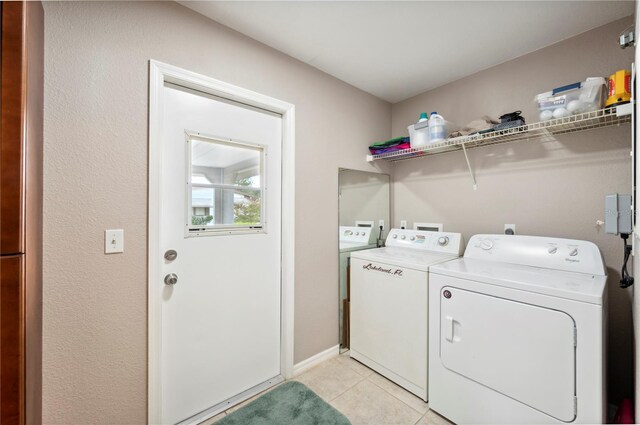 laundry area featuring washing machine and dryer and light tile patterned floors