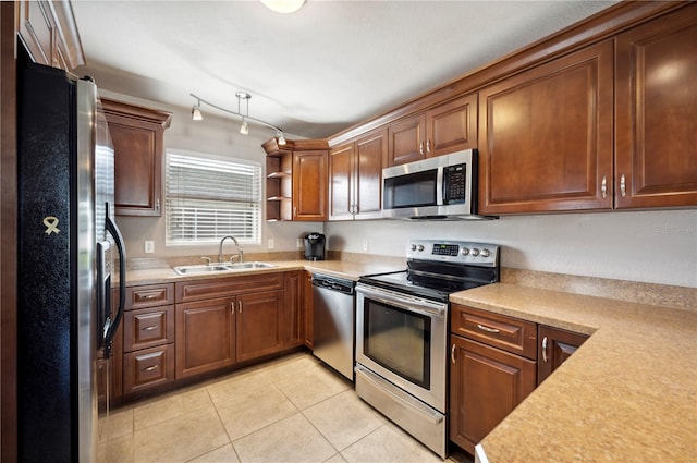 kitchen with appliances with stainless steel finishes, light tile patterned flooring, and sink