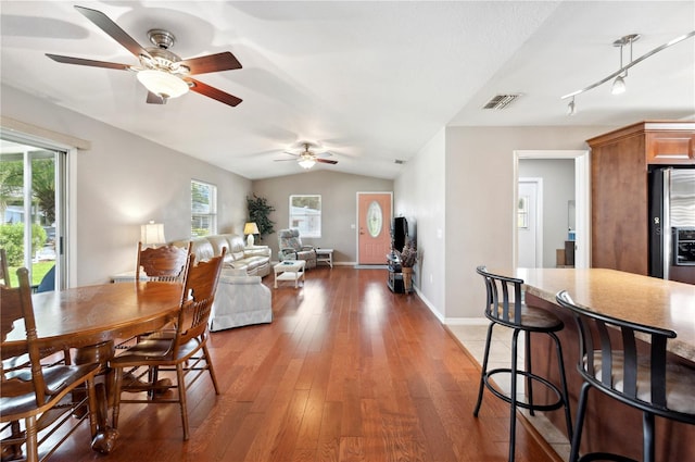 dining area featuring a healthy amount of sunlight, vaulted ceiling, hardwood / wood-style floors, and ceiling fan