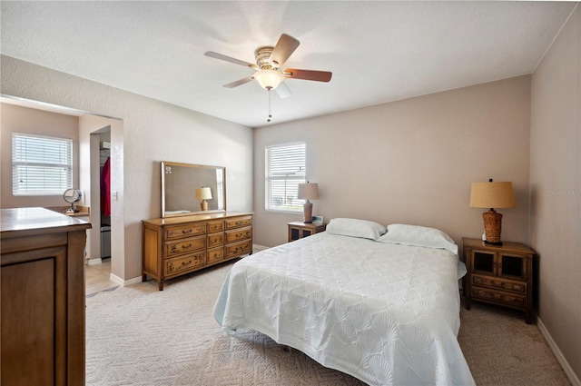 bedroom featuring multiple windows, ceiling fan, and light colored carpet