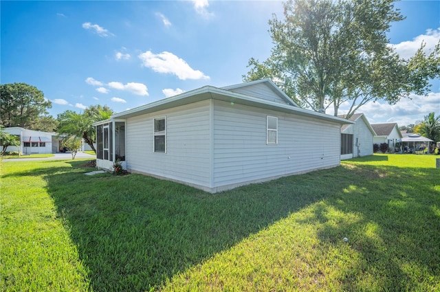 view of property exterior with a yard and a sunroom