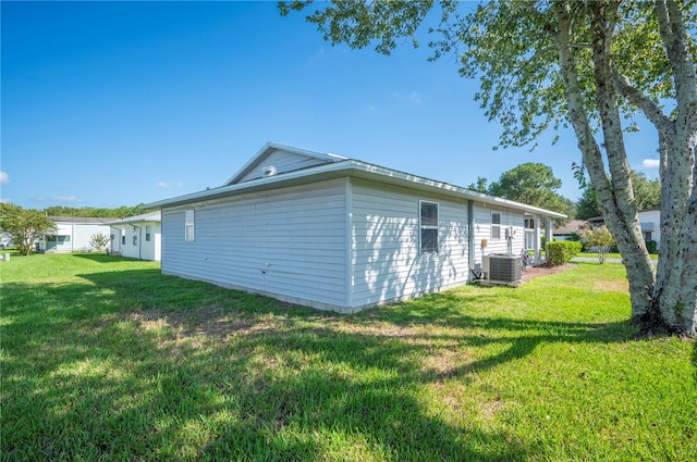 view of side of property with a yard and central AC unit