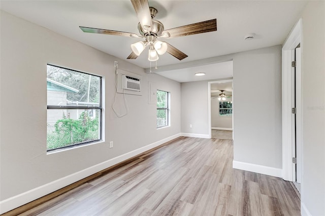 unfurnished room with an AC wall unit, light hardwood / wood-style floors, ceiling fan, and a healthy amount of sunlight