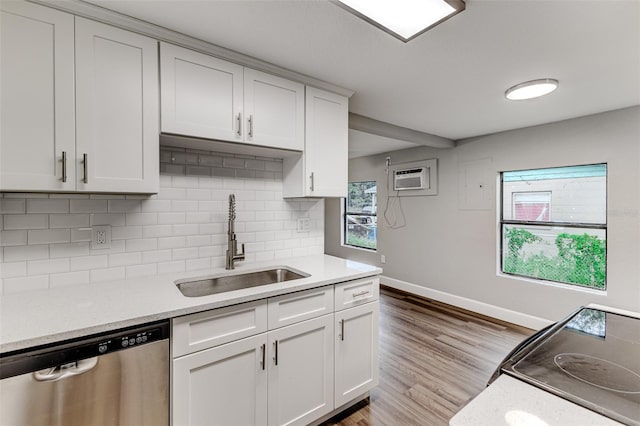 kitchen with a healthy amount of sunlight, stainless steel dishwasher, white cabinetry, and sink