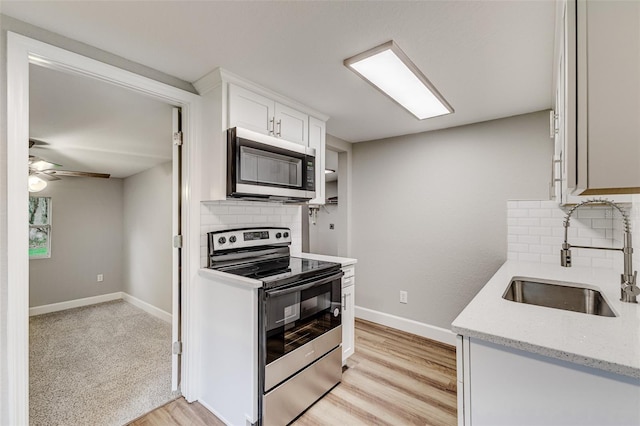 kitchen with backsplash, sink, stainless steel appliances, and white cabinets