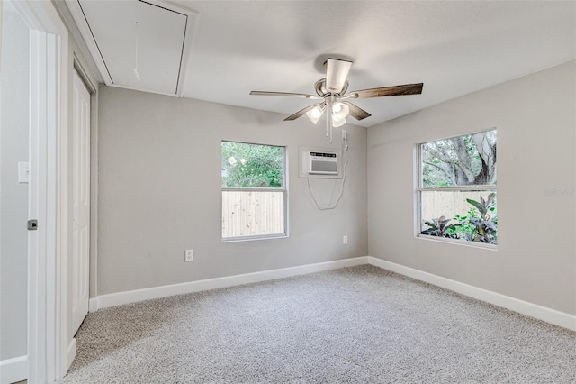 spare room featuring light carpet, an AC wall unit, ceiling fan, and a healthy amount of sunlight